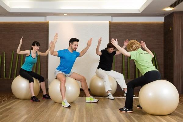 Páry cvičící na fit ballech