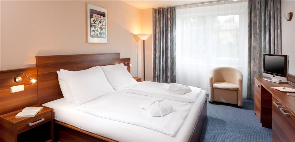 Pohled na postel ve standard pokoji hotelu Frymburk.