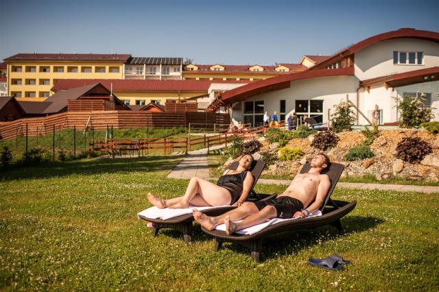 Pár opalující se na lehátkách před hotelem Frymbruk.