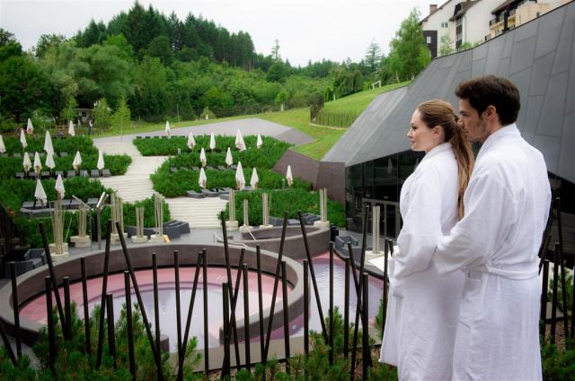 Pár v bílém županu sleduje okolí hotelu Breza.