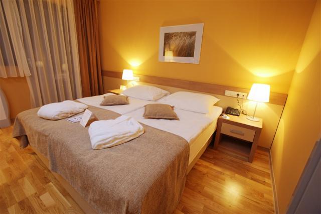 Pohled na manželskou postel v pokoji hotelu Breza.