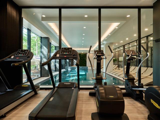 Pohled na běžící pásy ve fitness centru hotelu BERGO RESORT & S