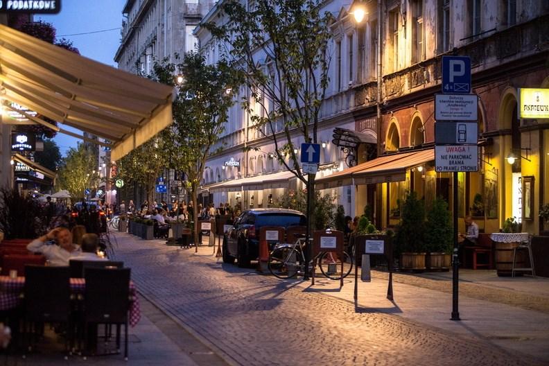 Letní večer poblíž Piotrkowska. Rušná dlážděná ulice, listnaté