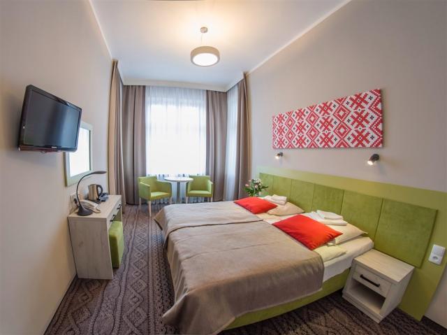 Pohled na dvoulůžkový pokoj směrek oknu hotelu NAT