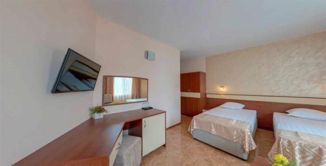 Hotel Sunny Flower-dvolůžkový pokoj pohled ke stolu s TV.jpg