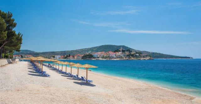 Primošten - pláž před hotelem Zora, slunečníky, lehátka, pohled