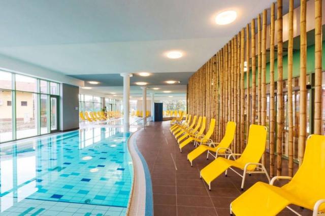 Hotelové wellness bazén vnitřní s lehátky.