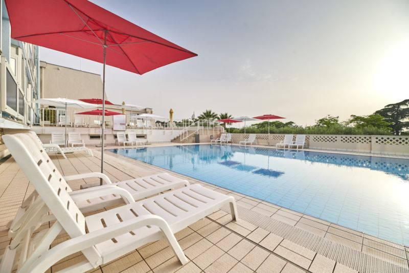 Hotel Plavi Plava Laguna - venkovní bazén s lehátky a slunečník