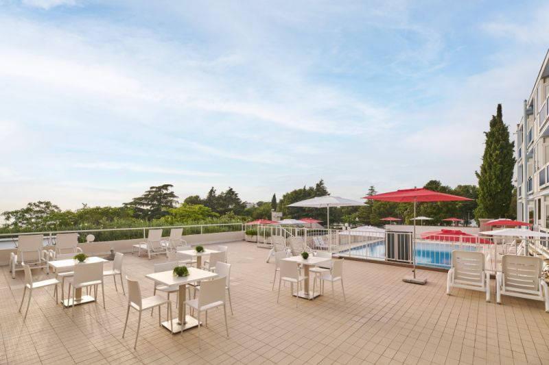 Hotel Plavi Plava Laguna - venkovní terasa u bazénu, stoly k po