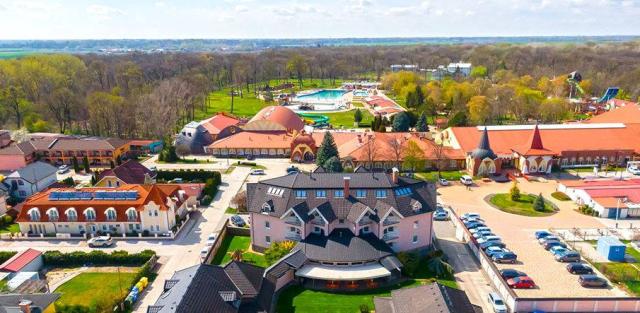 Hotel a termální koupaliště v pozadí.