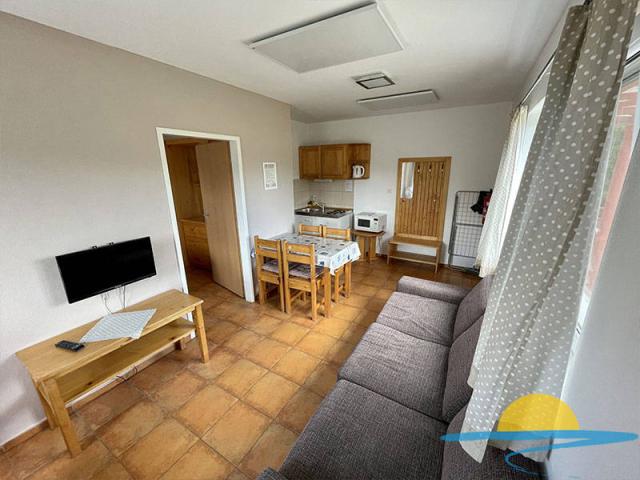 Apartmán obytná místnost rozkládací gauč, jídelní stůl, kuchyňs