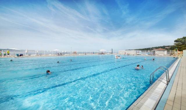 Bazén letní venkovní plavecký v areálu.