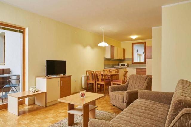 Apartmán kuchyně, jídelní kout, gauč.