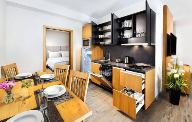 Apartmán Lux obývací pokoj s jídelním stolem a kuchyňským koute