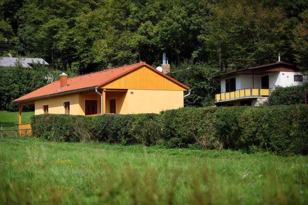 Nová zděná chata a v pozadí starší samostatná chata.