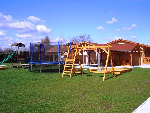 Zahrada s trampolínou a dětskými houpačkami