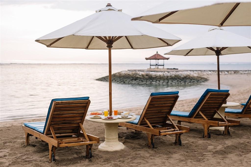 Respati Beach Hotel - pláž se slunečníky a lehátky.jpeg