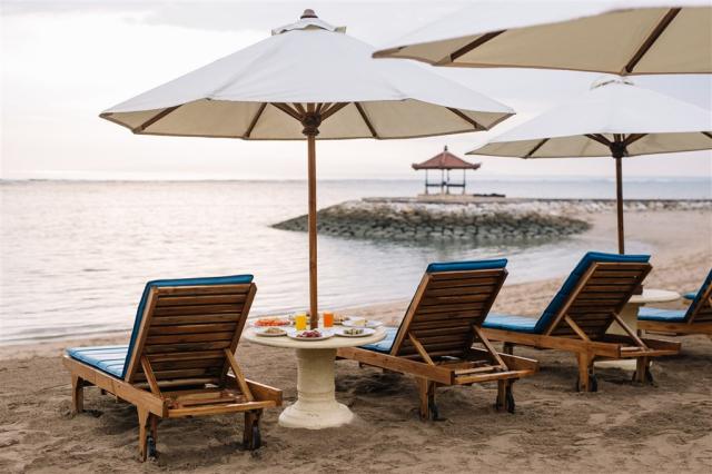 Respati Beach Hotel - pláž se slunečníky a lehátky.jpeg