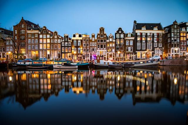 Noční pohled na historické budovy podél kanálu Singel v Amsterd
