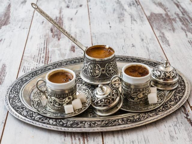 Traditional Turkish coffee in traditional silver cup with silve
