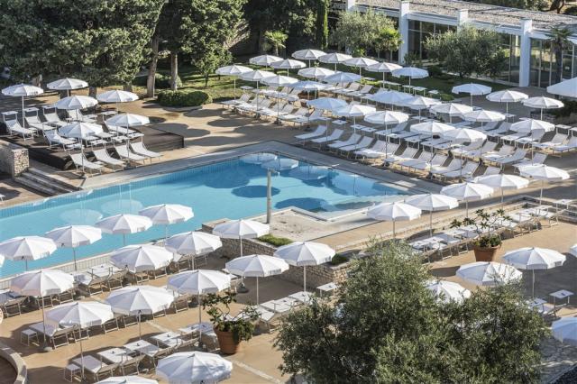 Ležadlá a slnečníky pri bazéne v areáli hotela Falkensteiner Cl