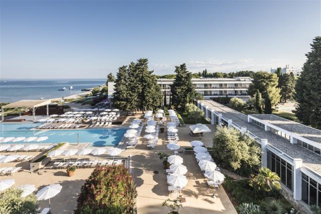 Ležadlá a slnečníky pri bazéne v hoteli Falkensteiner Club Funi